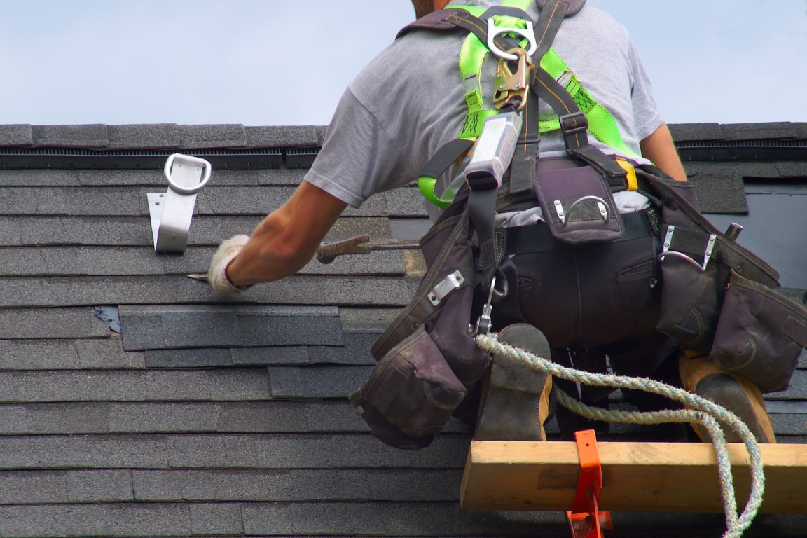 A picture of a person applying roof leak repair of a house