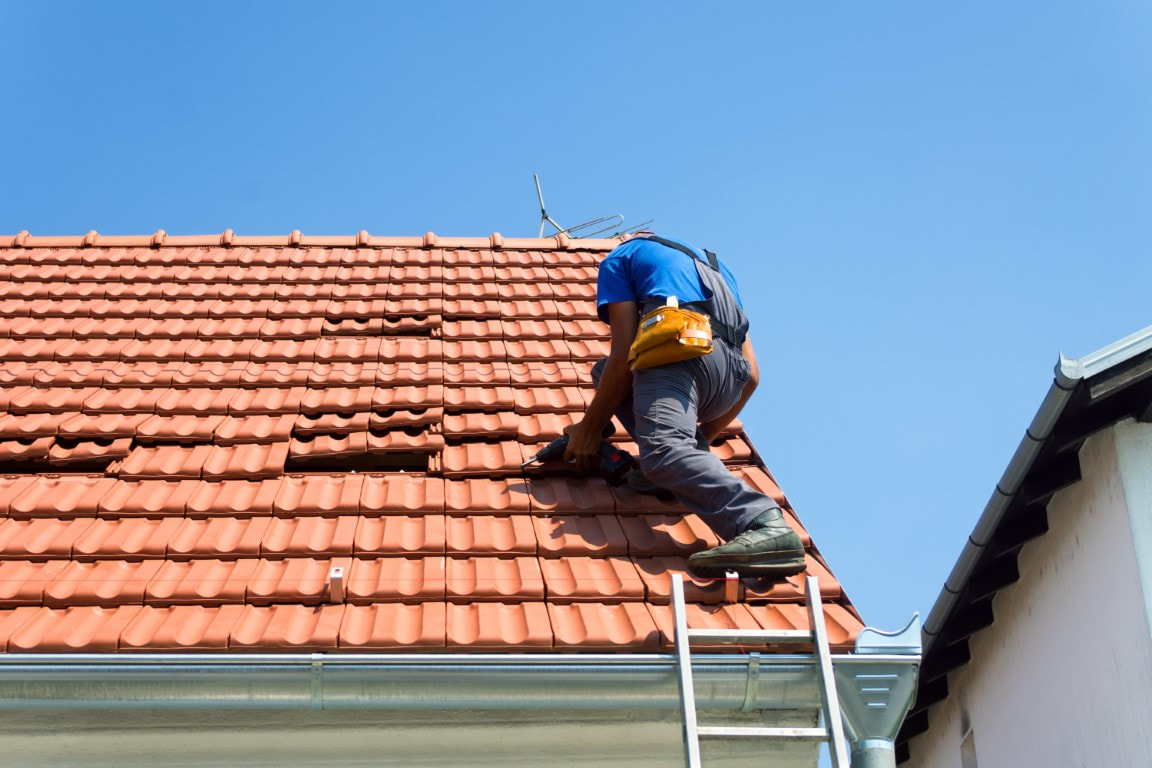 An image of a person working on a roof repair service