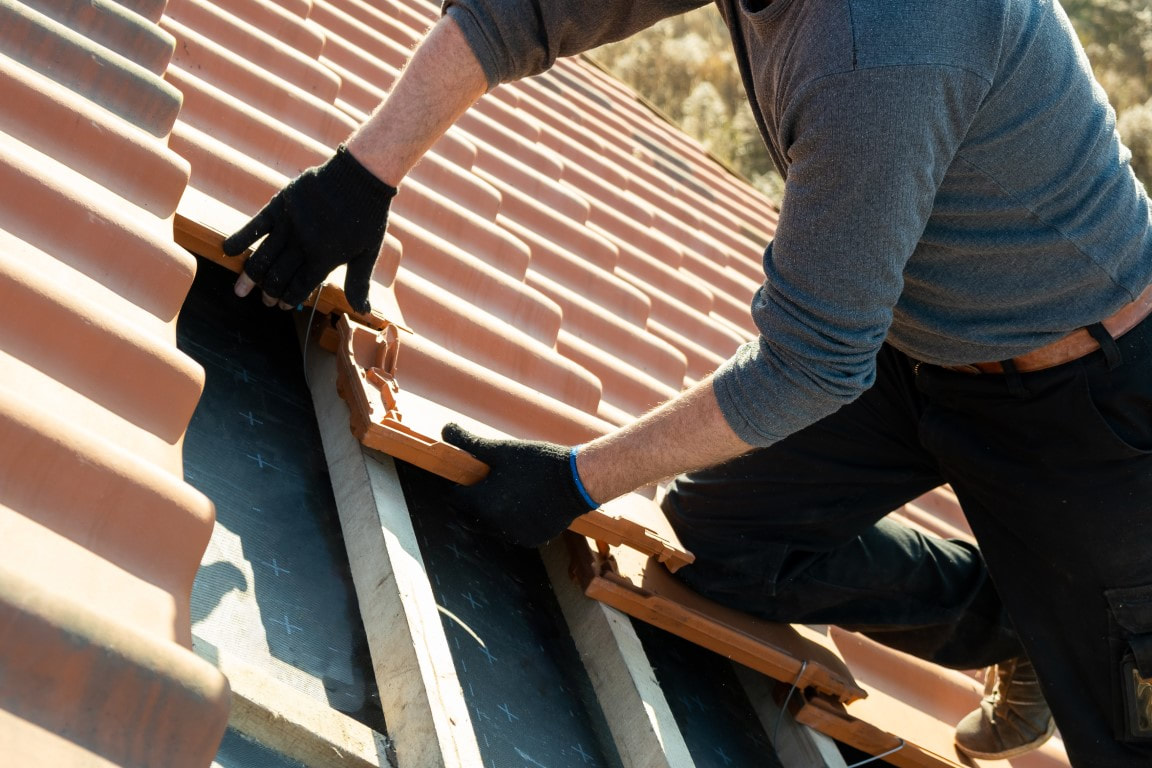 An image of a person working on a tile roofing service